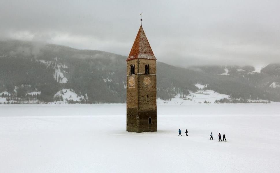 Church steeple peeking out of a frozen lake, Reschen, Italy
